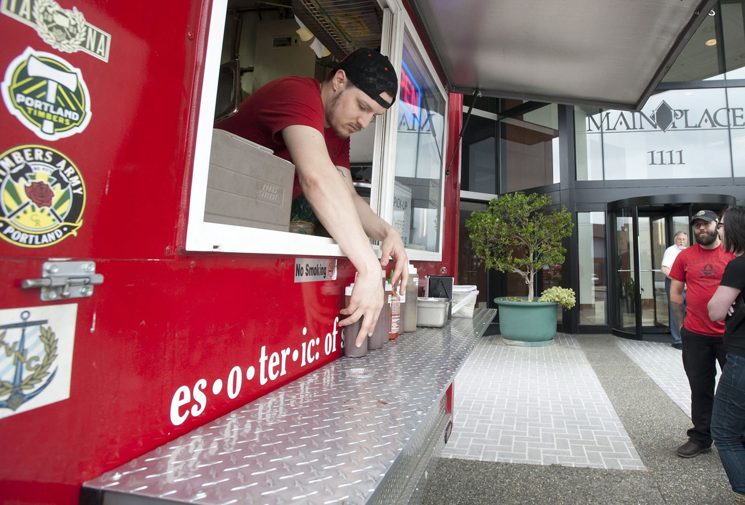 Daniel Honeycutt arranges condiments at the Esoteric BBQ food cart in Vancouver on Tuesday.