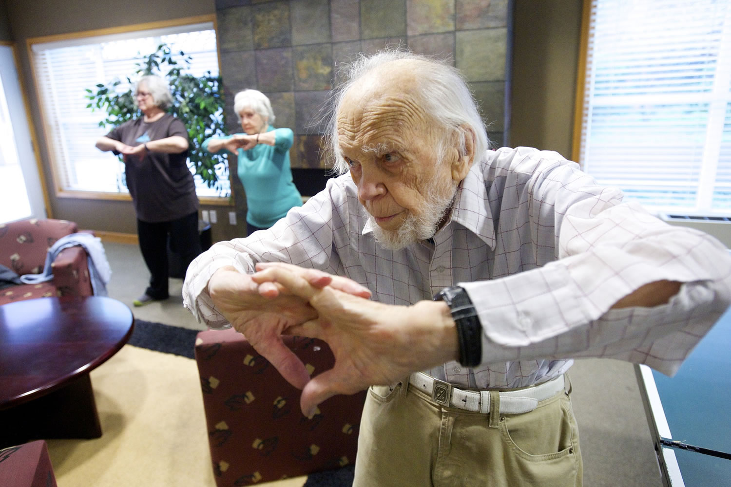 Harris Dusenbery, 100, and other Heritage Place residents take part in their regular workout session earlier this month.