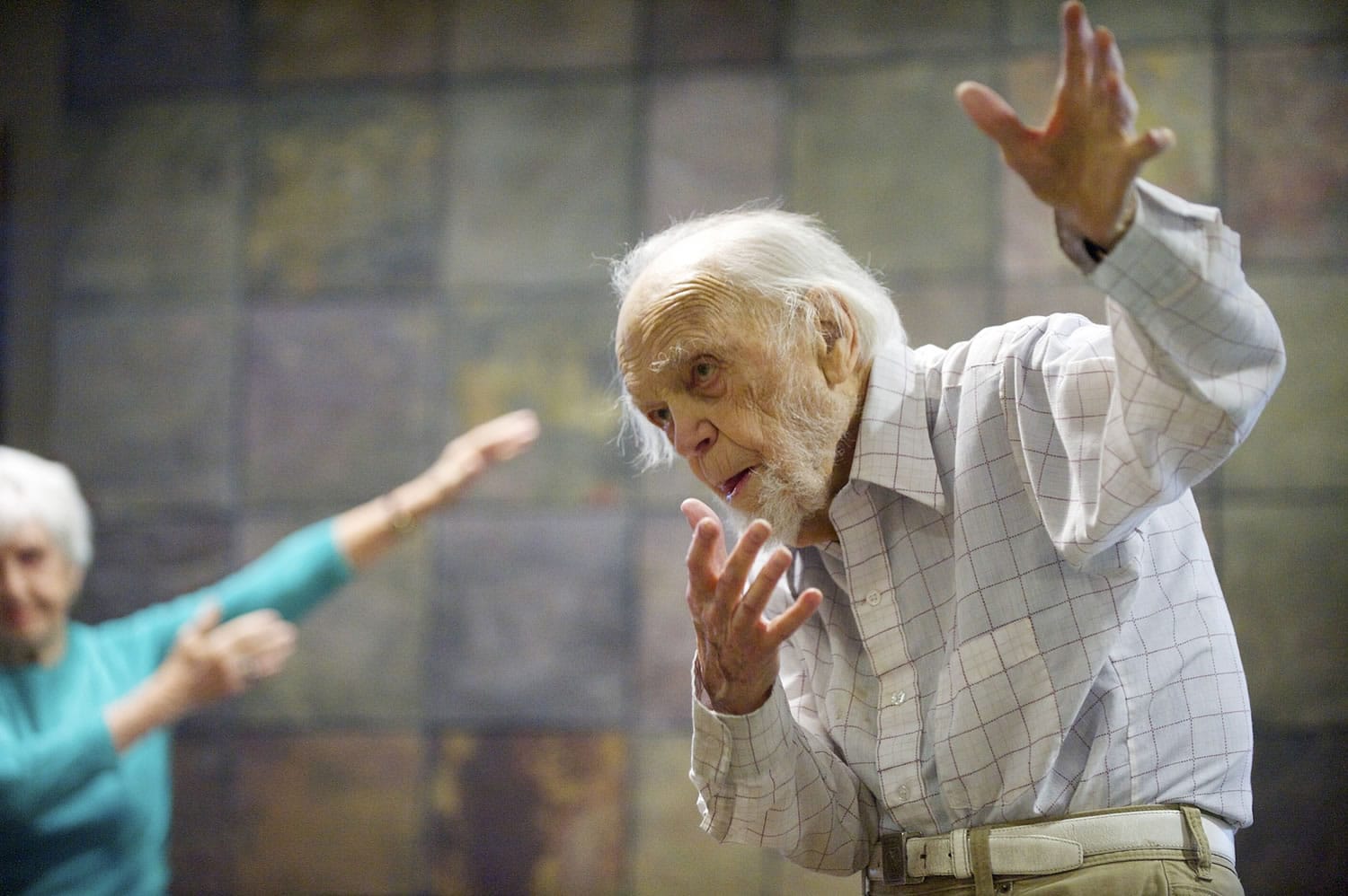 Harris Dusenbery, 100, takes part in an exercise class at his condo with other Heritage Place residents.