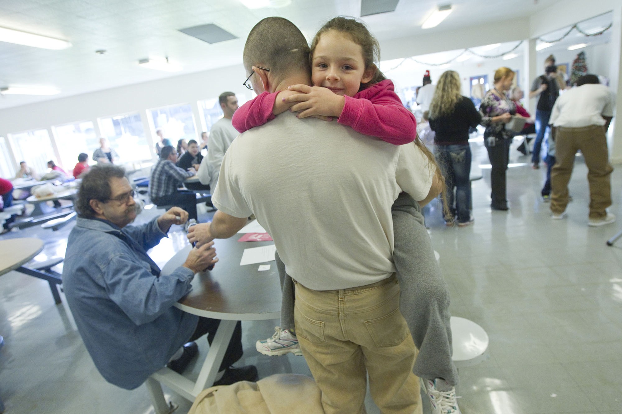Inmate William Shelden's daughter Anglea holds on tightly to her father at the Larch Corrections Center in Yacolt Sunday December 14, 2014. Inmates and their families spent the afternoon celebrating Christmas with music, presents and a visit from Santa.