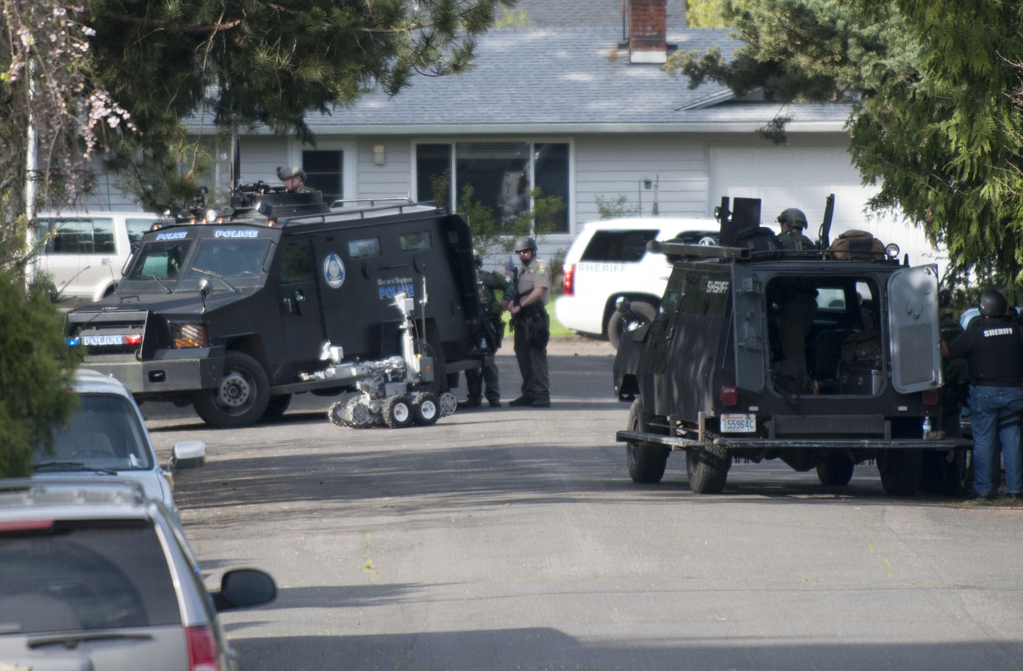 A SWAT team surrounds a home in the Lincoln neighborhood in Vancouver on Friday.