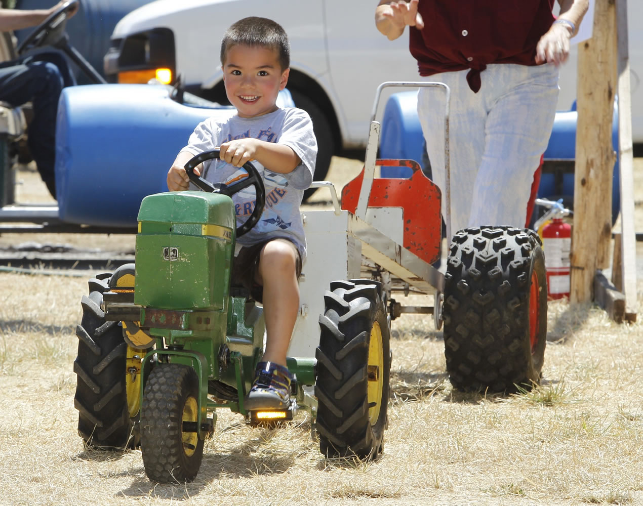 Collin Tobias, 4, of Bremerton rides a toy tractor Sunday at the Rural Heritage Fair, which took place at the Iron Ranch southeast of Ridgefield.