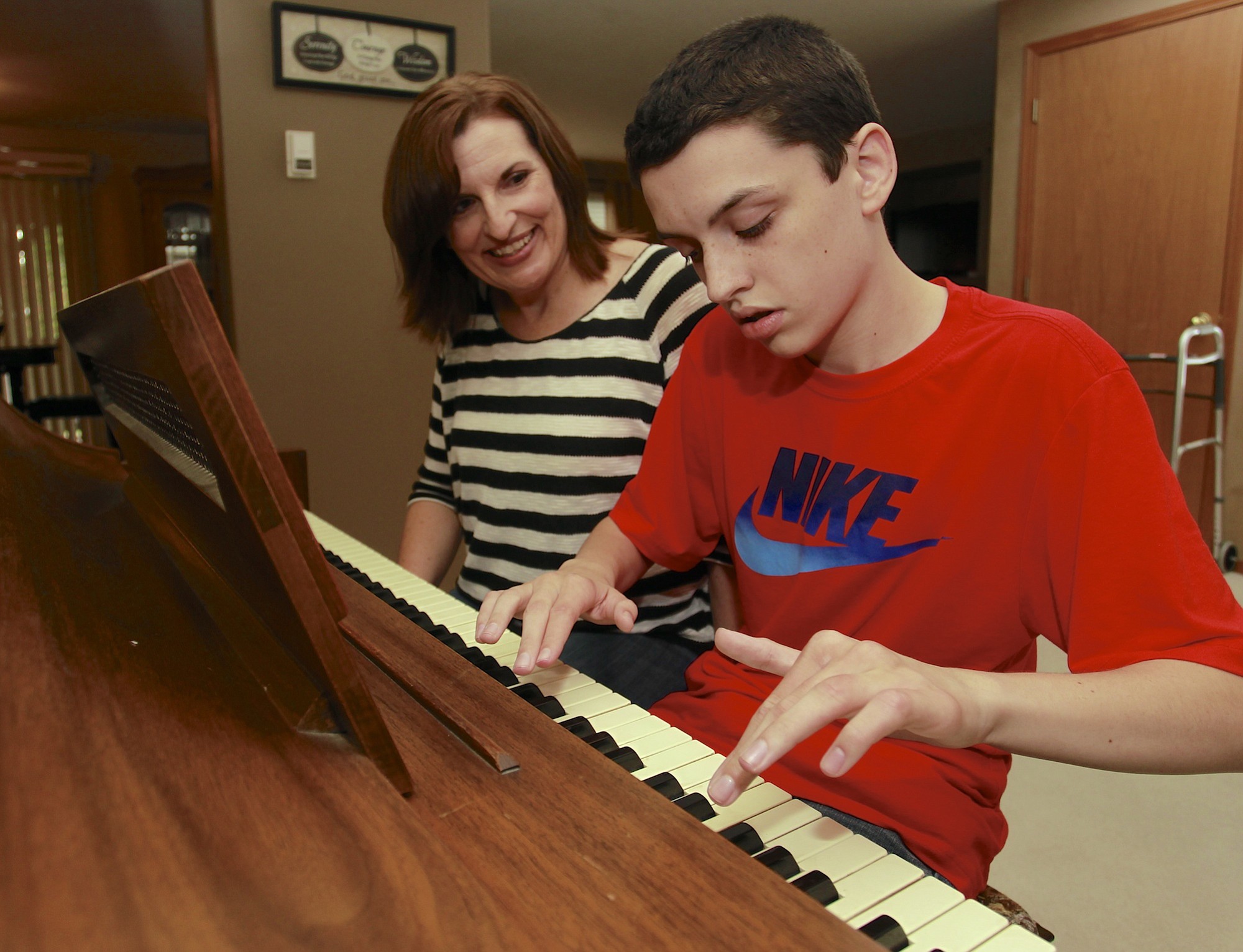 Steve Dipaola for The Columbian
Kari Sullivan watches her 14-year-old son, Nick, play Christmas songs on the piano at their east Vancouver home. Nick learns to play songs by ear.