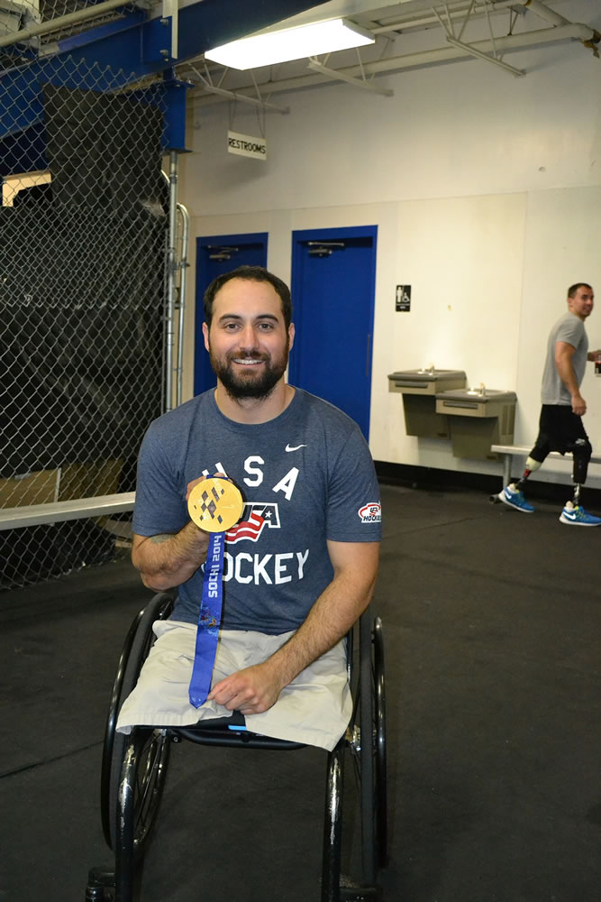 Josh Sweeney, shown with his 2014 Paralympic gold medal at Mountain View Ice Arena in Vancouver, is working with the Portland Winterhawks to promote sled hockey.