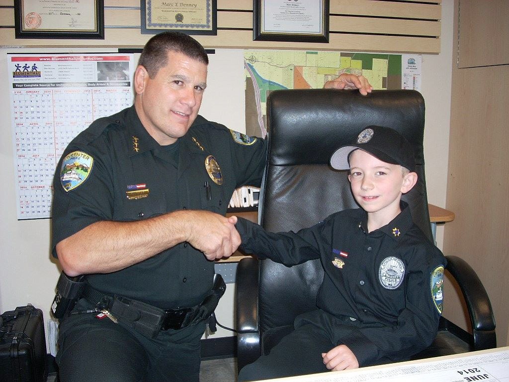 La Center: La Center Police Chief Marc Denney shakes hands with 8-year-old Brooklyn Johnson, who was sworn in as u201cChief for a Day.u201d