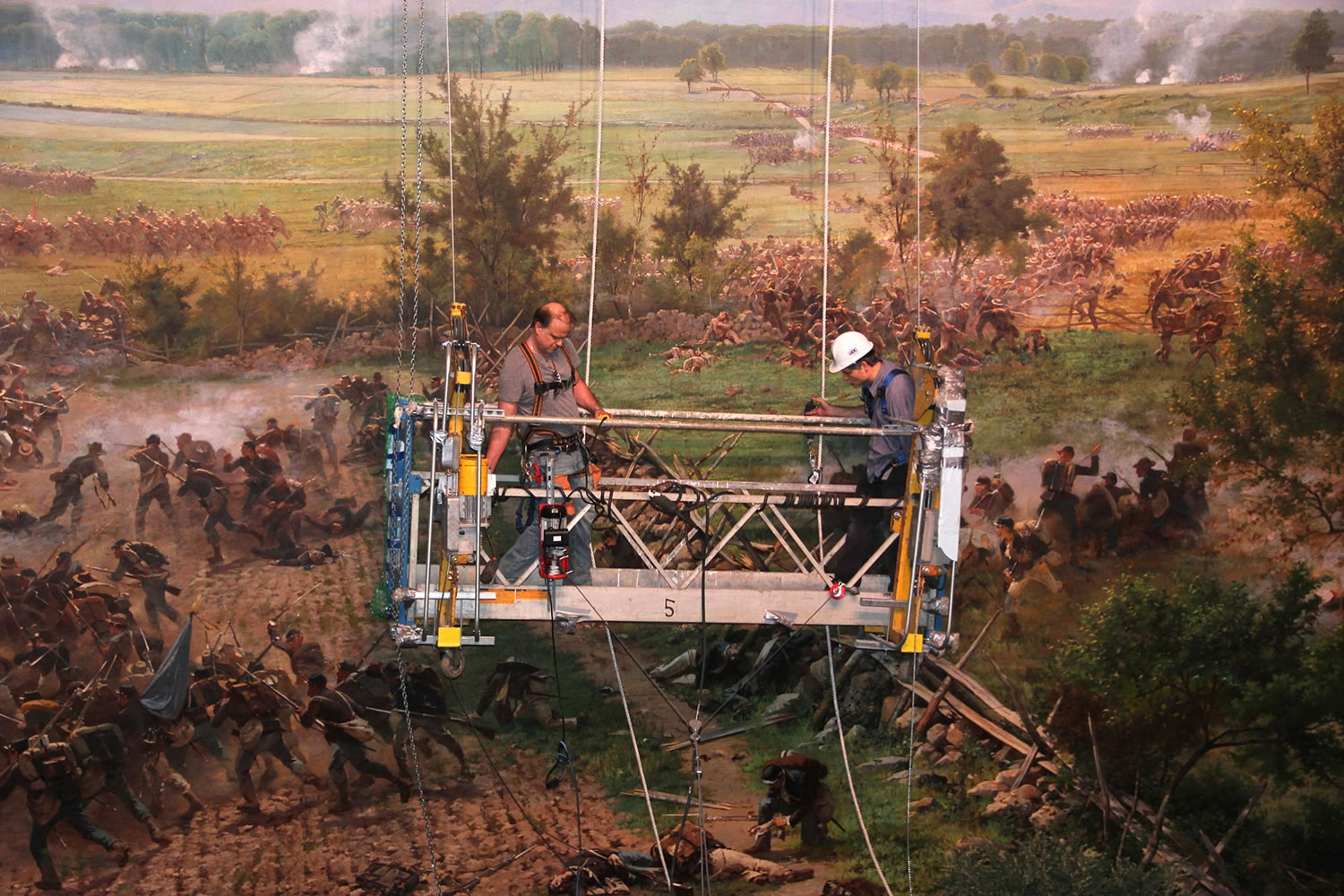 Workmen use a hoist to reach the upper levels of the Gettysburg Cyclorama during a routine cleaning in 2013.