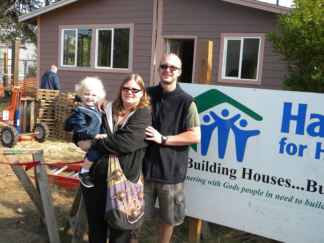 With 2-year-old Charles Deacon Frost, Michelle Frost and Charles Frost pose in front of their new home Friday.