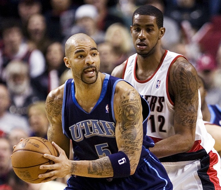 Utah Jazz center Carlos Boozer, left, looks to pass as Portland Trail Blazers forward LaMarcus Aldridge defends during the first half of their NBA basketball game in Portland, Ore., Sunday, Feb. 21, 2010.