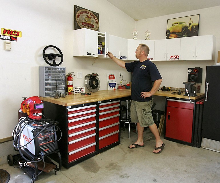 Mickey Remon shows off the storage cabinets above his work bench area at his Richfield, Ohio, home.
