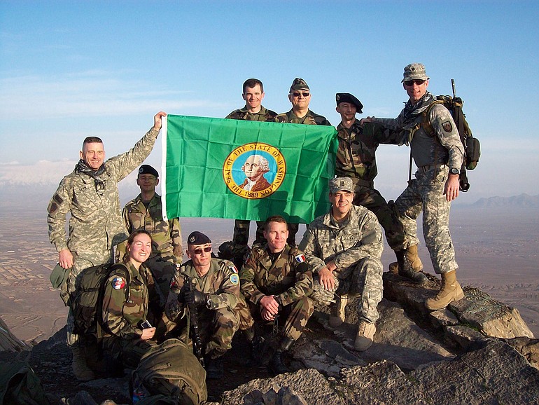 Col. Dan Kern, left, displays a Washington state flag after climbing a peak near Kabul with U.S.