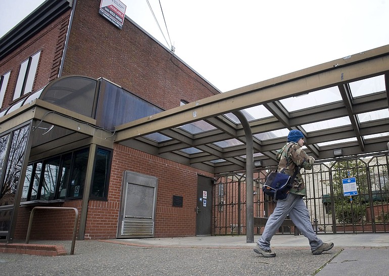 A man walks past the vacant former C-Tran bus depot on East Seventh Street on Monday.