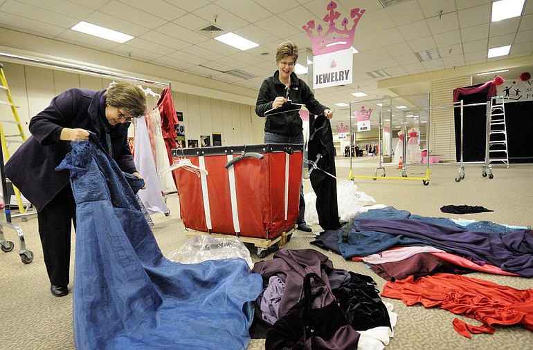 Operation Fairy Godmother organizers Denisse Haney, left, and Jan Redding select prom dresses for cleaning during preparation for this year's event.