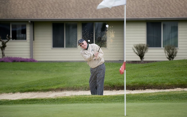 Dexter Garey of Fairway Village blasts out of the sand at the golf course near his home Tuesday.