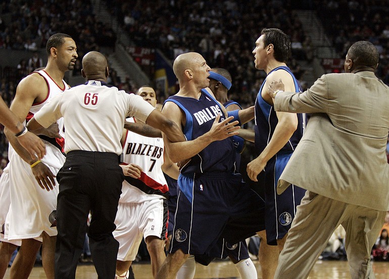 Juwan Howard, left, is held back by official Sean Wright (65) as Mavericks forward Eduardo Najera, second from right, is restrained after an altercation between Howard and Najera during the first half.