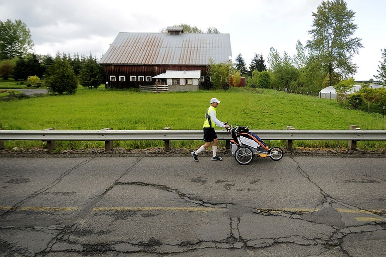 Mike Ehredt runs along Northeast 10th Avenue between La Center and Duluth on Monday as he journeys across the United States in recognition of service personnel killed in Iraq and Afghanistan.