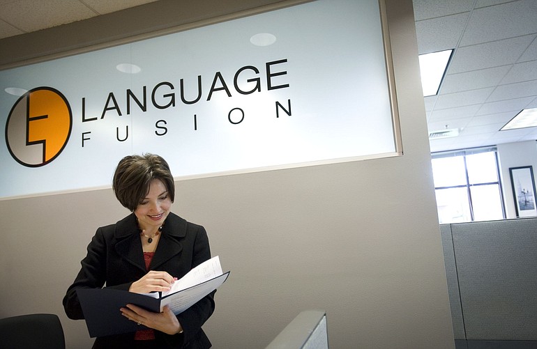 Olga Lafayette, owner of Language Fusion of Vancouver, goes through paperwork at her company's Main Street office.