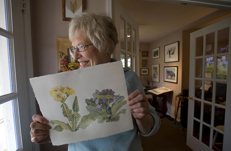 Artist Marilyn Wood Bolles holds one of her paintings.
