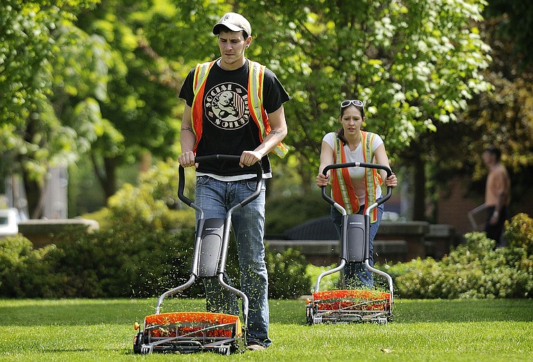 County Corrections work crew members Scott Mundell, left, and Katie Mattson use new Fiskars push mowers Wednesday to mow the lawn at the Clark County Courthouse.