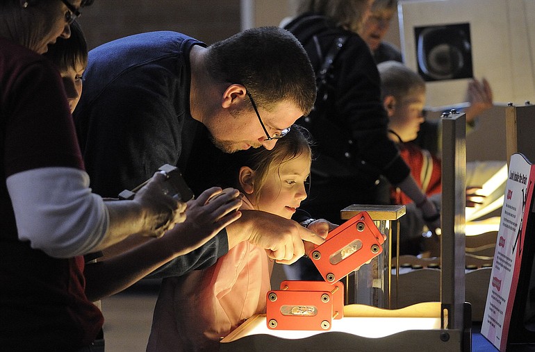 Jonas Barleen, left, looks at comparable organs of animals large and small with daughter McKenzie Barleen, 6, during Pacific Science Center's hands-on Science on Wheels fair Thursday at Cascade Middle School. The touring exhibit's free activities and shows continue from 4 to 8 p.m.