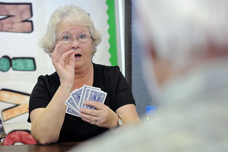 Melinda Schreiner converses in American Sign Language with Dwight Mackey, foreground, during a recent card game that was part of a recreation session for seniors at Southwest Washington Center of the Deaf and Hard of Hearing, now permanently housed in what used to be the Cascade Park Community Library.
