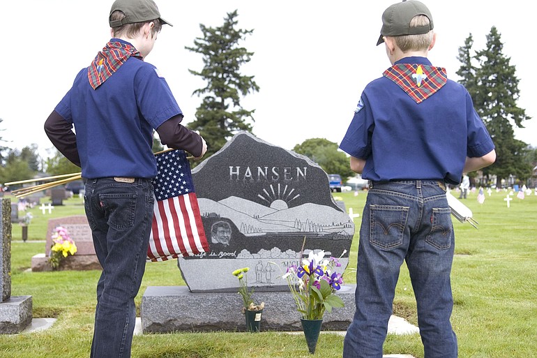Webelos scouts Austin Harvey, left, and Jack Kolosvary, both 10, decorate veterans' graves Saturday at Mother Joseph Catholic Cemetery.
