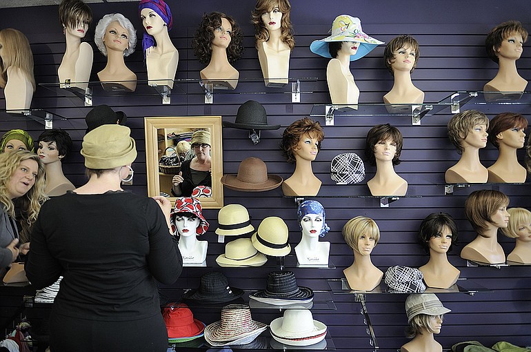 Krista Colvin, 43, tries on various hats after being fitted for a wig at Brenda Kay Hair Specialties in Portland.