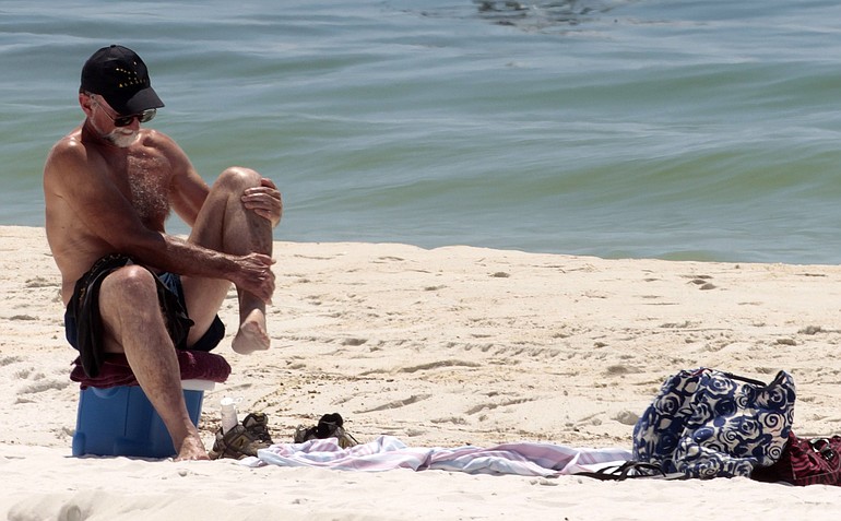 A sunbather applies sunscreen in Pensacola Beach, Fla.