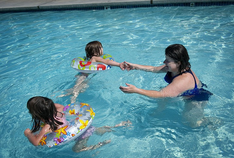 Laurie Hughes plays in the pool with her daughters Maura Bartlemay, foreground, 3, and Bailey Anne Bartlemay, 4, at their Vancouver apartment complex.