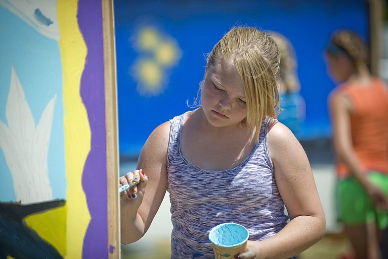 Taylor Wilcox, 10, of Vancouver, works on a collaborative painting at the International Food Festival on Saturday.