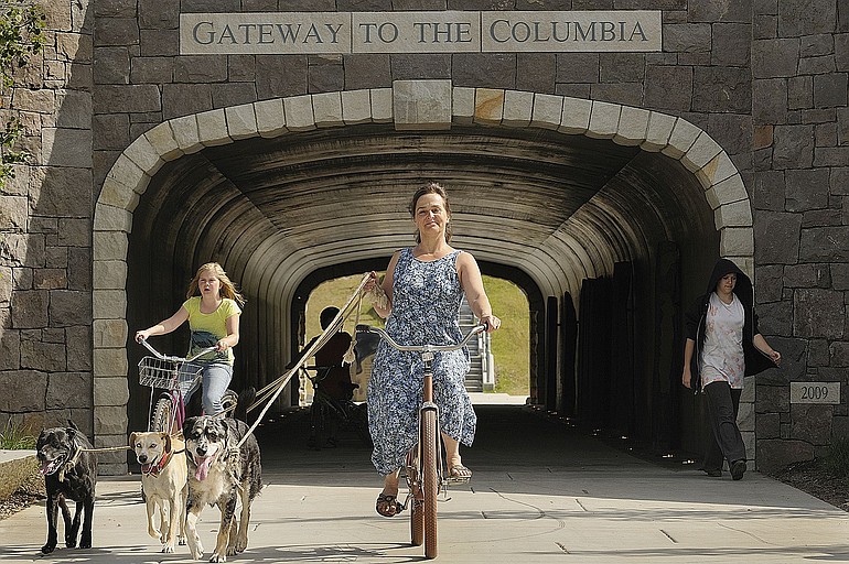 Bicyclist Bonnie Taylor, center, of Washougal emerges from the new Washougal tunnel with, from left, Shady, Toby-Ray and Romeo on a bike ride Monday.