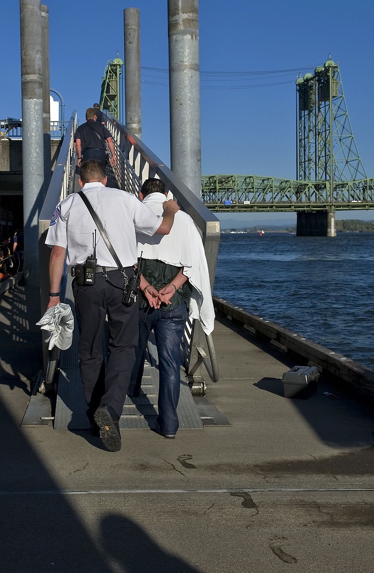 Emergency personnel escort a man, who witnesses say, jumped in to the Columbia River near The Vancouver Landing at Terminal One in a suspected suicide attempt on Wednesday.