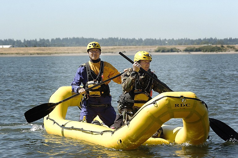 Jae Munson, left, a first-year tech rescue firefighter, and Todd Knoepell, a three-year tech rescue firefighter and paramedic with the Walnut Grove fire station, demonstrate water rescue procedure Wednesday at Wintler Park in Vancouver.