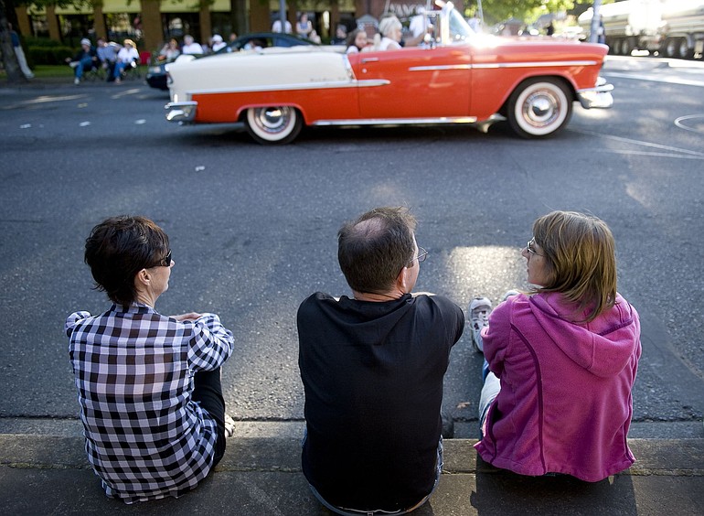 From left, Shirley Fire, Dan Herrick and Paula Gardner, all of Vancouver, watch vintage cars drive along Main Street on Saturday evening.