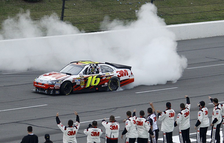 Greg Biffle does a burnout as his crew looks on after Biffle won the NASCAR Sprint Cup Series' Pennsylvania 500 auto race on Sunday.