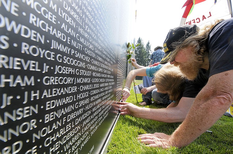 Vietnam veteran Donald R. Johnson and friend Charlotte Stewart trace the name on a panel of the replica of the Vietnam Veterans Memorial on Thursday in La Center. Johnson was searching for the name of another Donald R. Johnson who was killed during the same time he was serving as an Army medic in Vietnam. The American Veterans Traveling Tribute on display in La Center honors those killed in past wars and present-day conflicts. The exhibit is open 24 hours a day until 5 p.m.