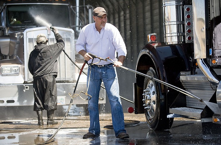 Bill Hines, owner of S &amp; W Pressure Wash, cleans a semi truck.