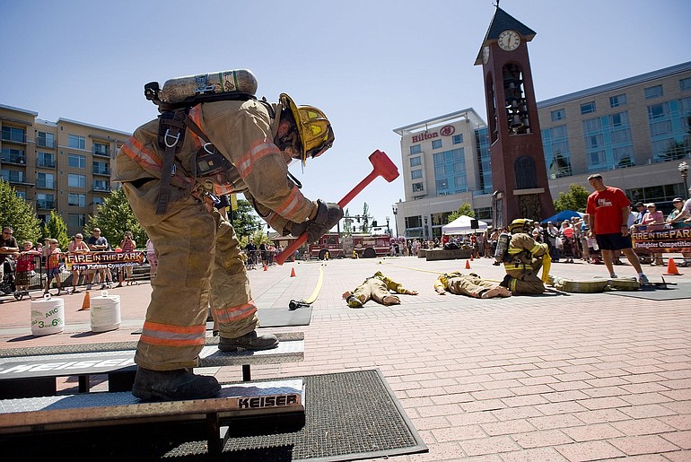 Vancouver Firefighter Sam Harrison competes in the firefighter challenge Saturday at Fire in the Park. Harrison was simulating chopping through a roof on a Keiser sled, a machine used for testing and training. The &quot;people&quot; lying on the ground nearby are weighted training dummies awaiting &quot;rescue.