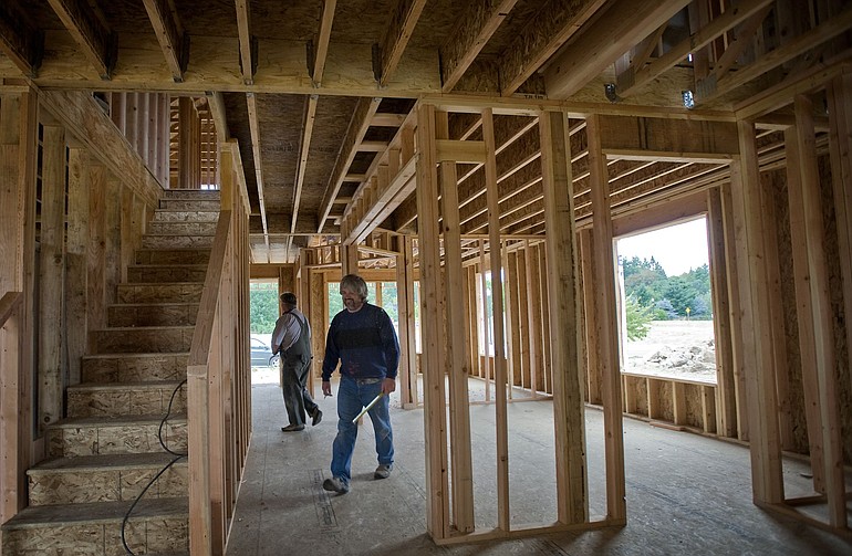 Plumbers and brothers Ted (foreground) and John Fritz work inside a house being built by Olin Homes in a subdivision in the Battle Ground school district.