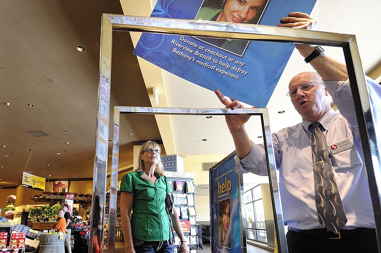 Michael Brown, right, a manager at the Safeway store in Washougal where Bethany Storro worked at the deli counter, places poster in display stands Friday as Nancy Neuwelt, Storro's mother, watches.