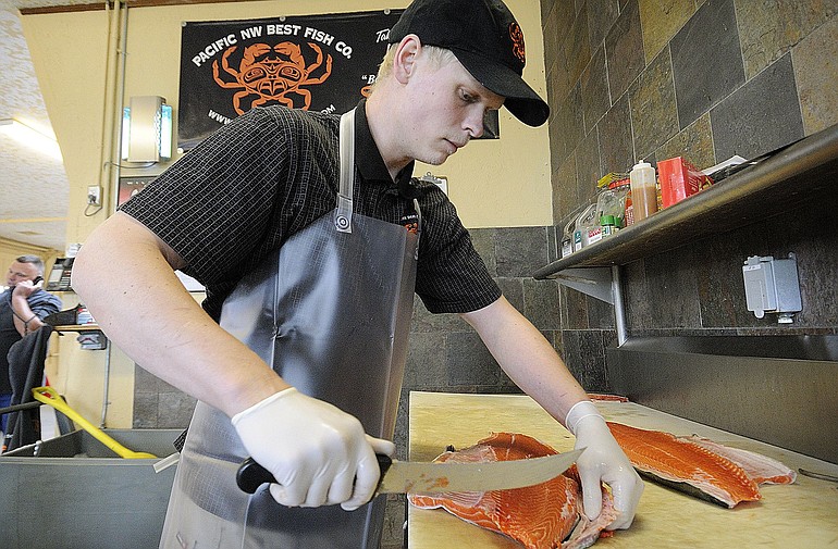 Dan Weston, a fishmonger at Pacific Northwest Best Fish Company, fillets an ocean run king salmon.