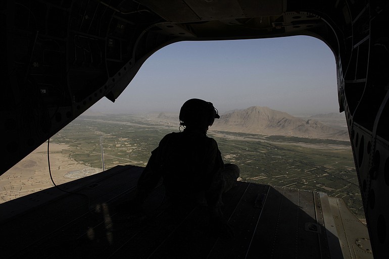 A crew chief looks out the open back of a U.S. Army Chinook helicopter over Zhari district, southern Afghanistan.