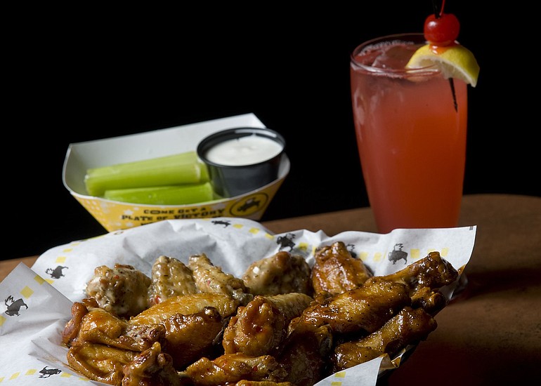 The 24-wing Sampler with Sweet BBQ, Parmesan Garlic, Medium classic and Honey BBQ sauces is served with celery sticks and a strawberry lemonade at Buffalo Wild Wings.