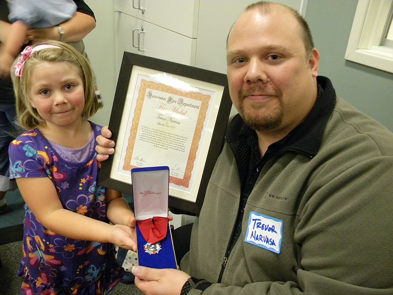 Trevor Narvasa, with daughter Erin, 5, received a commendation certificate and Fire Medal on Tuesday night from the Vancouver Fire Department.