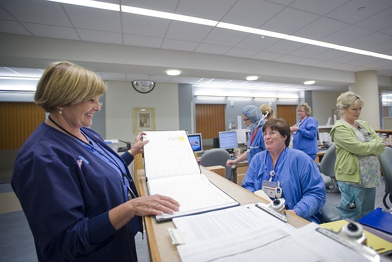 Gretchen Amacher, left, checks a log book to see how many babies have been delivered at Legacy Salmon Creek Medical Center since it opened in 2005.