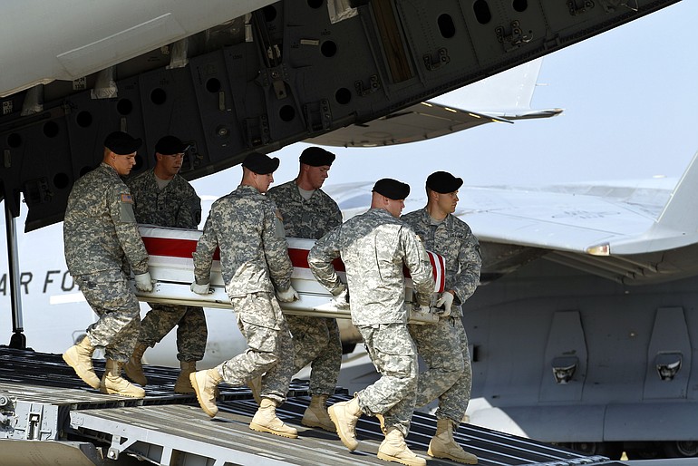 An Army carry team carries the transfer case containing the remains of Army Chief Warrant Officer Jonah D. McClellan of Battle Ground upon its arrival at Dover Air Force Base in Delaware on Wednesday.