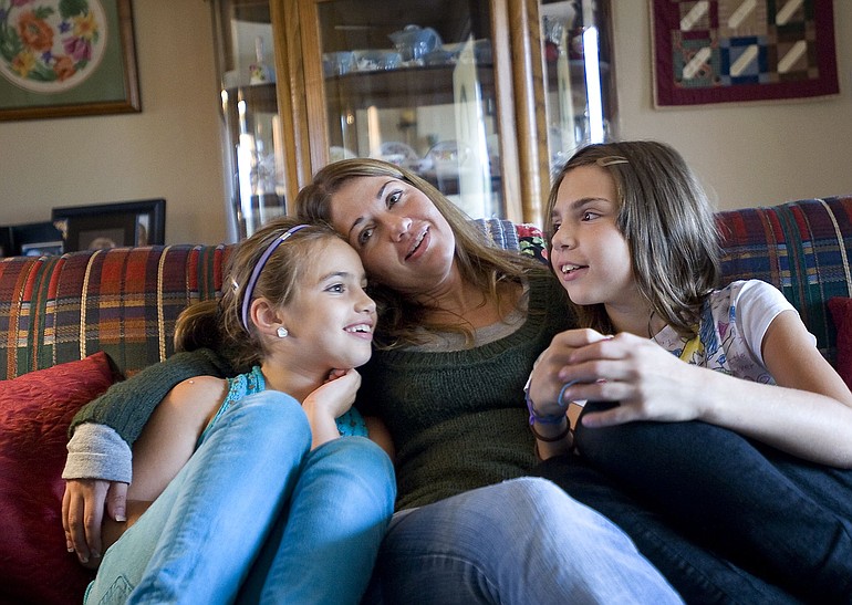 April Candilora poses for a portrait with her daughters Taylore, 11, right, and Samantha, 9, left, at their Felida home on Thursday.
