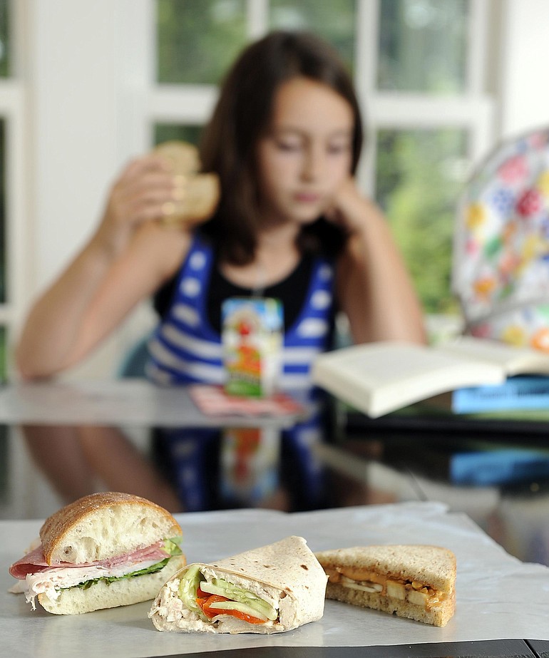 Eve Bishop, 11, enjoys a peanut butter, honey and bananas on white whole wheat bread sandwich.