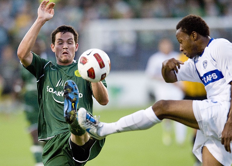 Portland Timbers Doug DeMartin, left, and Vancouver Whitecaps Willis Forko fight for the ball during Sunday's match at Merlo Field in Portland.
