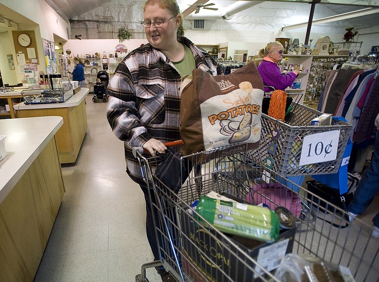 Washougal mother Cheryl McGuire walks toward her car with a cart of food Tuesday after her first trip to the food bank at Inter-Faith Treasure House in Washougal.