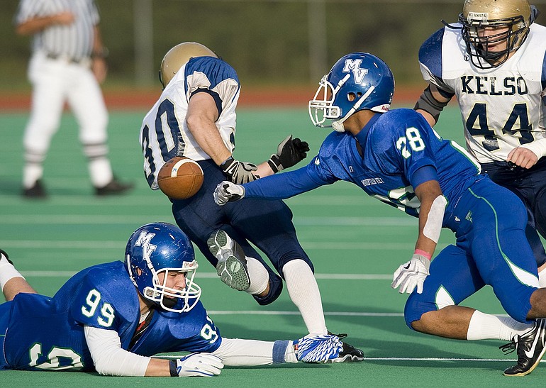 Mountain View's P.J. Jones (28) swats the ball from Kelso ball carrier Riley Miller (30) during Friday's 3A Greater St. Helens League game at McKenzie Stadium.